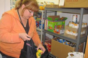 Renee Law, an administrative specialist for the East County Family Resource Center, fills a backpack with food items for the Weekend Backpack Program. The program benefits children in need at local schools.