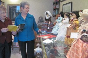 Two Rivers Heritage Museum volunteer Bernice Pluchos (left) and Volunteer Coordinator Lois Cobb (right) admire one of the newest exhibits that features a doll collection of Presidential First Ladies wearing ball gowns of their era. The museum, located in downtown Washougal, reopened today after displays were cleaned and rearranged.