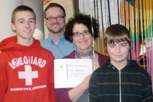 Skyridge Middle School Principal Aaron Smith and Librarian/Media Specialist Connie Pappas, and two students grin after receiving their mini-grant for Kindle eReaders. Pappas was awarded funds to buy the devices as part of a technology pilot program.