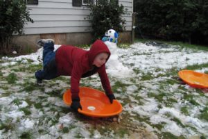 Max Galekovich, of Camas, enjoyed several slushy rides on a snow saucer in his yard Thursday. He and his siblings Jordan Richards and Emily Rothery (both not pictured) also created a snowman and a "snowkid." The smaller of the snow figures featured a pickle for a nose, because no carrots were available. Schools in Camas and Washougal were closed Thursday.