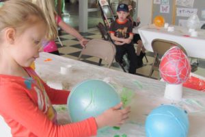 Annika Stupfel decorates a balloon during a spring break art camp at the Jack, Will and Rob Boys and Girls Club in Camas.  Below, at left, kids enjoyed craft making at the Camas Library. The library also showed a free movie every day last week.