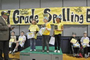 Camas Superintendent Mike Nerland presents prizes to the winners of the all-district spelling bee recently. From left are Elizabeth Gillespie, Ali Burris and Jacob Leetham. Second-grade students from Grass Valley, Lacamas Heights, Helen Baller and Prune Hill elementary schools participated.