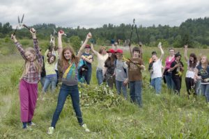 Students raise their hands in victory after completing the blackberry bush removal project at Steigerwald Lake National Wildlife Refuge.  Sixth-graders from Jemtegaard and Canyon Creek middle schools spent two days last week learning about the Columbia River Gorge and surrounding area.