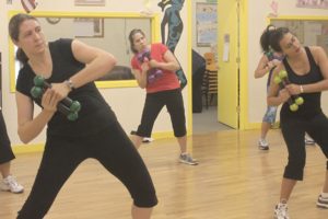 Participants in a Zumba toning class follow instructions from Rachelle Wish, a certified personal trainer and fitness instructor.