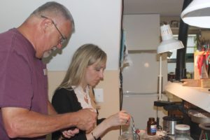 Gene Dietzen assists student Joan Anderson during a recent jewelry making class. His said his passion is teaching.