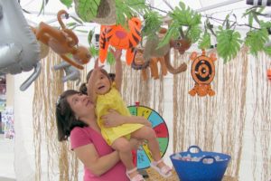 Joanna Duran gives her daughter, Delaney a lift to look at the animal prizes offered by Pure Wellness, a chiropractic and massage clinic in Washougal.