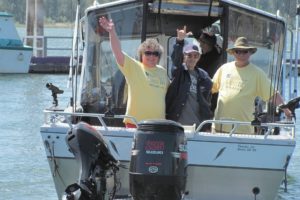 John Russell (center) sends a signal of joy to his wife and daughter Thursday, as he sails away from the Port of Camas-Washougal to go fishing for the first time in three years. Helping this 91-year-old's wish come true was nurse Denise Hood (left), her husband Randy (right) and their friend Matt Justis.