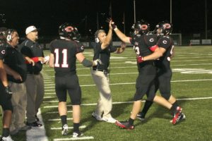 Camas High School football coaches and players congratulate John Norcross after his second touchdown Friday, at Doc Harris Stadium.