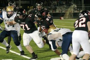 Camas football players Chip Sudbeck (77), Keegan Dyehouse (72), Daniel Anderson (71) and Zach Anderson (22) clear the road for Zack Marshall (25) Friday, at Doc Harris Stadium.