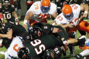 That is not a football in Odin Coe's grasp, it's the helmet of the Rainer Beach quarterback. The Papermakers flattened the Vikings 56-0 Friday, at Doc Harris Stadium, for their first playoff victory in three years.