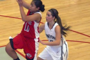 Kat DeVera (left) delivers two points for the Papermaker girls basketball team Wednesday, at Union High School. Camas smashed the Titans 48-21.