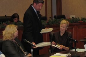 Mayor Paul Dennis (center) presents Councilwoman Helen Gerde (right) with a plaque, pin and other mementoes as Councilwoman Linda Dietzman (left) looks on last night. It was the final council meeting and workshop for Gerde, who announced in October that she planned to retire after 15 years on the council. "I've learned a lot from Helen," Dennis said.  "I think we all have." Gerde first began serving in city government as an appointed member of the Parks and Recreation Commission.  She was then named to the Planning Commission, an entity she served on for two years before running for city council.  She was first elected in 1995, running unopposed in all four of her bids for the seat. Last night, the city council selected Tim Hazen to fill the remaining year of Gerde's four-year term. See page A1 for additional details.