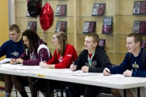 Camas High School seniors (left to right) Odin Coe, Addison Owen, Melissa Williams, Drew White and Kurt Yinger eagerly sign their college letters of intent Wednesday.