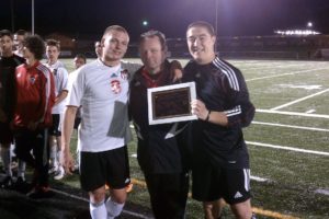 Camas High School soccer coach Roland Minder celebrates his 250th victory with seniors Drew White (left) and Zach Anderson (right). The Papermakers shutout Shorecrest 3-0 Tuesday, at Doc Harris Stadium in Camas, to advance to the state quarterfinals.