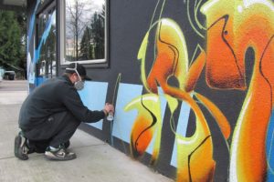 Local artist Bobby Johnson works on a "piece" at Limitless Snow-Wake-Surf in Washougal. The owner, Eric Hargrave, his him change the design every six months or so. "I let him do what he does best on the building," Hargrave said.