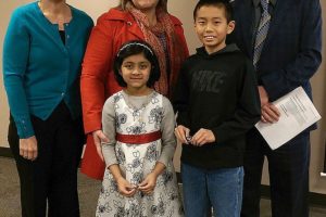 Camas students Shalaka Deshpande and Kandai Shimada won prizes at the national level for their entries into the annual School Bus Safety Week competition. Here, they are honored by, from left, Mary Tipton, Camas School Board chairwoman; Laura Nowland, transportation director; and Mike Nerland, district superintendent.