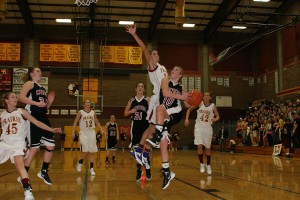 Camas senior Sydney Allen (right) soars by Prairie senior Heather Corral to score a basket Friday, at Prairie High School. The Papermakers led 26-24 at halftime, before the Falcons outscored them 42-19 in the second half to win 66-45.