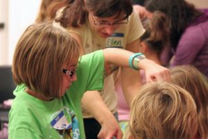 Children and their parents try to untie a human knot as part of a game during a sleepover at the Camas Public Library last fall. The event is one of the many programs the library offers free of charge.