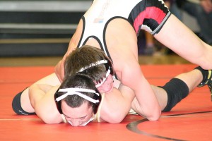 Tye Lommasson locks the arms of Evergreen's Jordan Moore and grinds his face into the mat, at Camas High School. The Papermaker defeated the Plainsmen 12-3 to capture the 128-pound 4A Southwest Washington district championship.