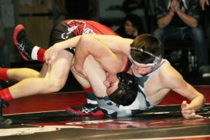 Camas freshman Rylan Thompson keeps Union sophomore Taggart Hartwig on the mat during the 126-pound 4A district championship match Saturday, at Camas High School. Thompson won 4-2.