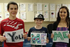 Jemtegaard Middle School students (left to right) Corey Barton, Casey Schulenbarger and Kim Kanning hold signs which accompany a poem for their anti-bullying performance, based on the T.V. show, "What would you do?"