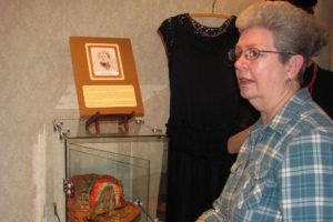 Volunteer Coordinator Lois Cobb points out a hat collection currently on display at the Two Rivers Heritage Museum. Cobb is one of the museum's most dedicated volunteers, logging 431 hours in 2012 alone.