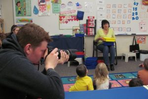 CHS student Donovan MacGowan photographs students at the Papermaker Preschool for their yearbook. MacGowan is designing and printing the yearbook for his senior project.