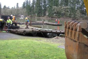 Crews from the City of Camas and Ballard Diving and Salvage work to pull a section of old dock from Lacamas Lake at the site of the former Moose Lodge on Friday. The wood and other debris were hauled away from the property yesterday for disposal. Four large logs, 6 to 7 feet in diameter, which were used as supports underneath the dock, were discovered. The old growth Douglas fir logs could be salvaged, then sold, traded or re-purposed to benefit the project.