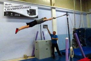 Coach Zdravko Stoianov spots Riley Gorsuch on the high bar. Gorsuch is one of 13 gymnasts who will compete for the Vancouver Elite Gymnastics Academy in the USAG men's state gymnastics championships Saturday and Sunday, at the Clark County Event Center.