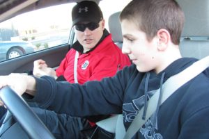 Geary Enbody, an instructor with the 9-1-1 Driving School in the 192nd Avenue Station, talks to Washougal High School freshman Brody Oberg. Enbody, an officer with the Woodland Police Department, is among the law enforcement personnel who serve as knowledge/skills examiners. The driving school provides teen drivers safety education and certification courses, medical assessment drives and programs for mature drivers.