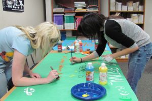 Noelle Schmidt (left) and Tess Russell put the finishing touches on a poster for the annual Japanese Culture Festival, held in the WHS commons on Saturday, April 6. Festival proceeds benefit class activities and Japanese earthquake relief efforts.