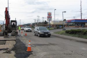 A flagger at the 100 block of "C" Street, in Washougal, temporarily slows traffic as crews from Northwest Natural Gas relocate a gas line in preparation for construction of a roundabout. Several business owners in the vicinity of the road work recently talked about seeing fewer customers.