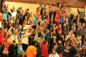 Students at Jemtegaard Middle School eagerly raise their hands to donate $1 for the opportunity to help duct tape teachers Anna Linde and Ron Schlauch to the gym wall.