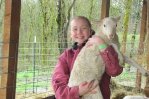 Kiara holds Tina, one of her sheep, at the family home in Washougal. She is raising the animals for 4-H and will show them at the Skamania County Fair this summer.