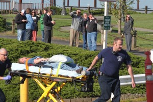 Port of Camas-Washougal employees look on as Camas-Washougal Fire Department paramedics and a volunteer "victim" takes part in this morning's emergency drill. In recent years, the port has held similar events at its industrial park and airport.