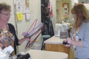 A volunteer assists a customer with a purchase at the Inter-Faith Treasure House thrift store, in Washougal. Executive Director Nancy Wilson (not pictured) said business at the thrift store has decreased 50 percent since the work to widen State Route 14 started.