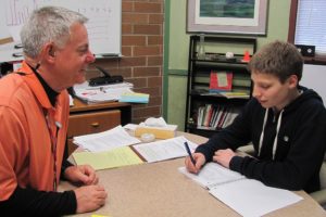 Ron Carlson is retiring after 40 years in education. He has served as principal of Jemtegaard Middle School in Washougal for the last four years. Here, he visits with seventh-grader Tucker Meyer.