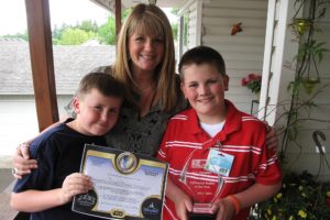 A.J. Geaslen (right) shows off his TOPSoccer Buddy of the Year award with his brother Tommy (left) and mother Molly (center).