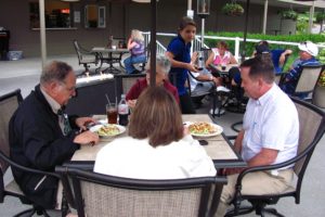 Guests enjoy salads and beverages by a warm fire Friday, during the grand opening of the Lower Terrace restaurant at Camas Meadows.