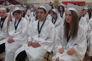 Hayes Freedom seniors Garth Vaughan, Jacob Ritter, Casey Ortiz and Taylor Johnson (from left to right) enjoy the view from the front row during their graduation ceremony, in the Liberty Middle School gym. While Ortiz has signed with the Navy, other graduates are planning to attend four-year colleges, Clark College or trade schools, according to Principal Amy Holmes.