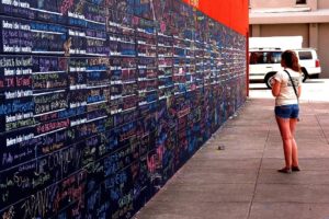 Nicole Hay contemplates on the sentences written on the "Before I Die," wall.  The wall began when a woman in New Orleans wrote on an abandoned house. Soon, other people began writing what they wanted to do before they died. Eventually, it was moved to the outside wall of the art museum downtown New Orleans, which houses the "30 Americans" exhibit of  African American art over the past century.