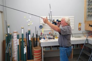 Carl Francis "Kerry" Burkheimer III smiles at the finished product of a fly rod built in his downtown Washougal shop. The company assembles and ships close to 1,500 rods a year to fishermen all over the world.