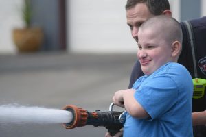 Gaerett Bailey of Hathaway Elementary learns how to handle a fire hose during the Young Men in Action program, which is coordinated by the Camas-Washougal Rotary Club.