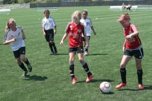 Members of the Washington Timbers Junior Academy kick a soccer ball around on the new turf fields at the Harmony Sports Complex, located on the border between Vancouver and Camas.