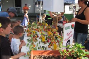 Kids give their creations one final inspection before the Camas Farmer's Market Veggie Derby last year. Awards were given out for most use of veggies, farthest/fastest and most creative.