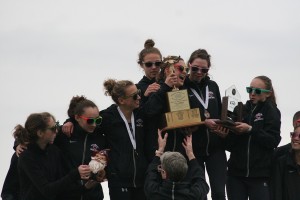 Members of the Camas High School girls cross country team grab hold of their state championship trophies. The News Tribune, in Tacoma, honored the Papermakers for having the best athletic programs in the 4A classification.