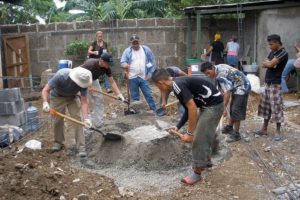 Side-by-side, members of the Gateway Community Church Nicaragua Mission Team and  residents of Tipitapa mix cement for the expansion of a church. Some of the same team members helped build the original church nine years ago.