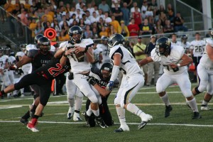 Camas High School seniors Vince Huber (21) and Nick Gadbaw (22) smother the Canby quarterback Friday, at Doc Harris Stadium.