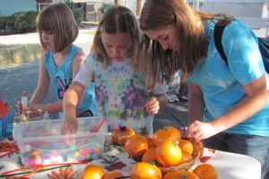 Children participate in pumpkin decorating during the Camas Farmer's Market Harvest Festival.