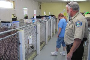 Camas-Washougal Animal Control Officer Rick Foster and West Columbia Gorge Humane Society volunteer Anne Fromm visit dogs at the WCGHS shelter in Washougal. Foster wants to educate local residents about laws that affect them and their pets.